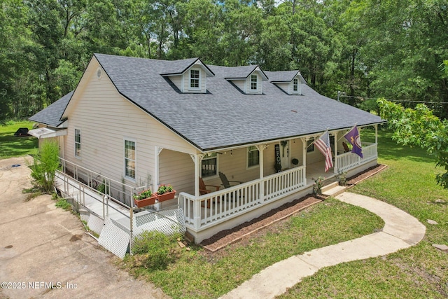 2443 SE 150th St, Starke, FL 32091 - farmhouse inspired home featuring roof with shingles, a porch, a front yard, and view of wooded area