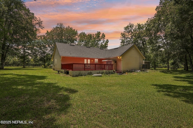2443 SE 150th St, Starke, FL 32091 - property exterior at dusk with a wooden deck, a yard, and roof with shingles