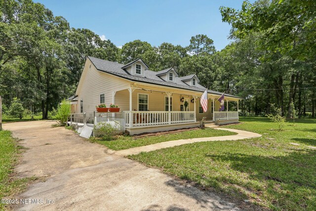 2443 SE 150th St, Starke, FL 32091 - view of front of property with a porch, concrete driveway, and a front lawn