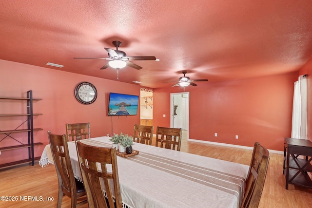 2443 SE 150th St, Starke, FL 32091 - dining room with light wood-style flooring, a ceiling fan, and a textured ceiling