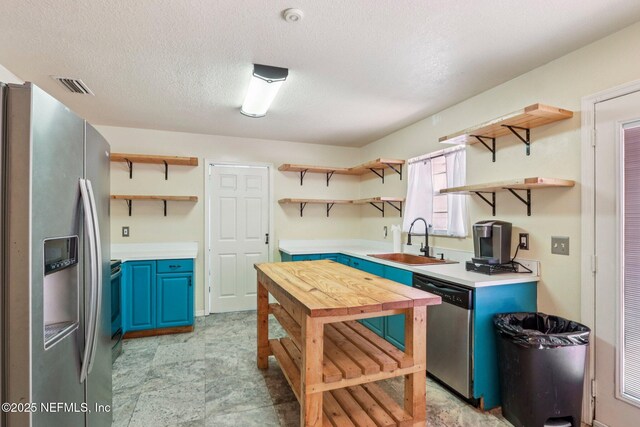 2443 SE 150th St, Starke, FL 32091 - kitchen featuring open shelves, appliances with stainless steel finishes, blue cabinets, light countertops, and a textured ceiling
