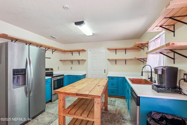 2443 SE 150th St, Starke, FL 32091 - kitchen featuring appliances with stainless steel finishes, open shelves, blue cabinetry, light countertops, and a textured ceiling