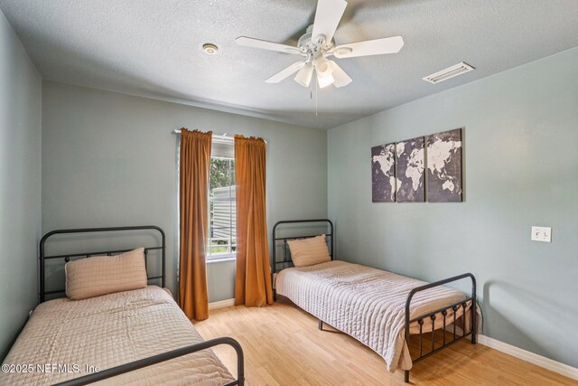 2443 SE 150th St, Starke, FL 32091 - bedroom with wood finished floors, a textured ceiling, and ceiling fan