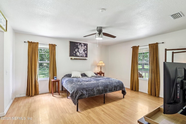 2443 SE 150th St, Starke, FL 32091 - bedroom with light wood-style flooring, a textured ceiling, and ceiling fan