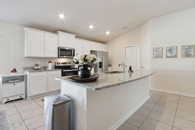 14 Rambling Ln, Palm Coast, FL 32164 - kitchen with appliances with stainless steel finishes, a sink, light tile patterned flooring, an island with sink, and white cabinets