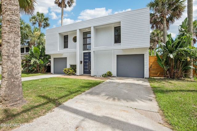 248 11th St, Atlantic Beach, FL 32233 - view of front of home featuring concrete driveway, an attached garage, a front lawn, and brick siding