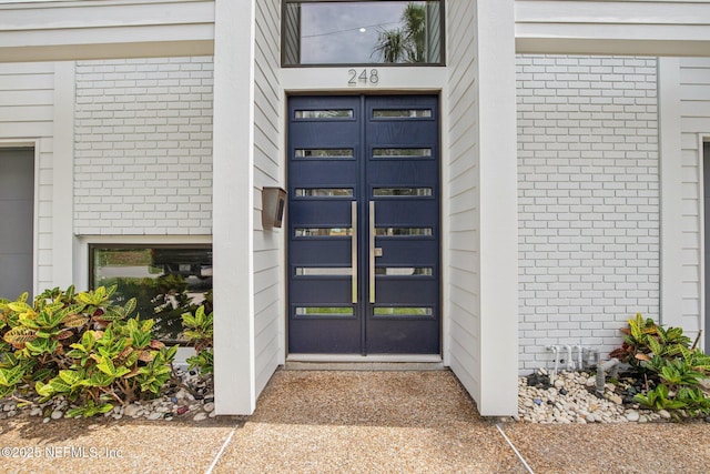 248 11th St, Atlantic Beach, FL 32233 - view of exterior entry featuring brick siding and french doors