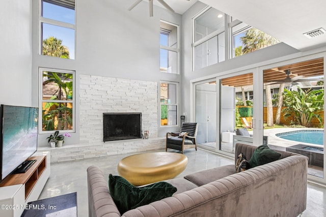 248 11th St, Atlantic Beach, FL 32233 - living room featuring plenty of natural light, a towering ceiling, a ceiling fan, and a fireplace