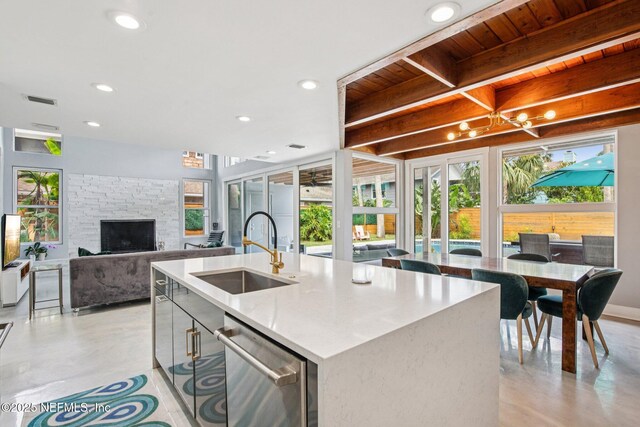 248 11th St, Atlantic Beach, FL 32233 - kitchen with dishwasher, finished concrete floors, recessed lighting, a stone fireplace, and an island with sink