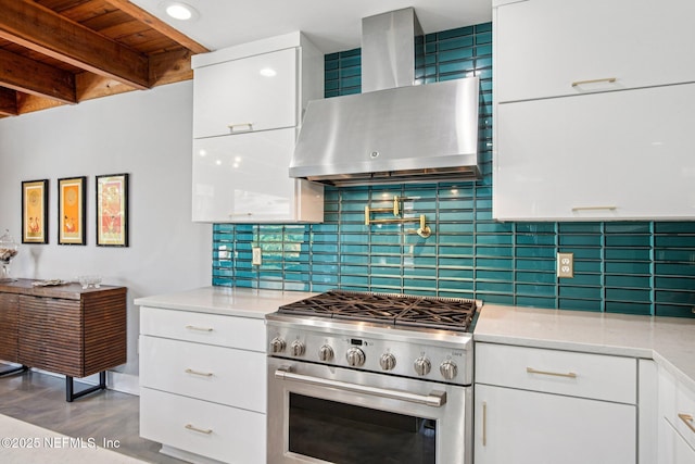 248 11th St, Atlantic Beach, FL 32233 - kitchen with high end stove, wall chimney exhaust hood, white cabinetry, decorative backsplash, and light stone countertops