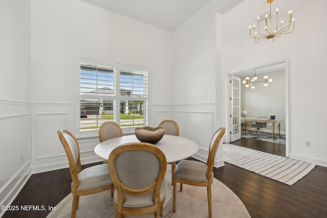 97 Marquesa Cir, Saint Johns, FL 32259 - dining area featuring a chandelier, a decorative wall, wood finished floors, a towering ceiling, and a wainscoted wall