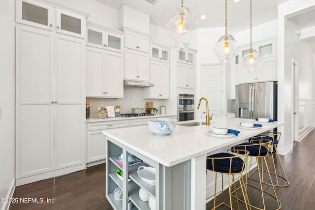 97 Marquesa Cir, Saint Johns, FL 32259 - kitchen with appliances with stainless steel finishes, dark wood-style floors, a kitchen island with sink, and decorative light fixtures