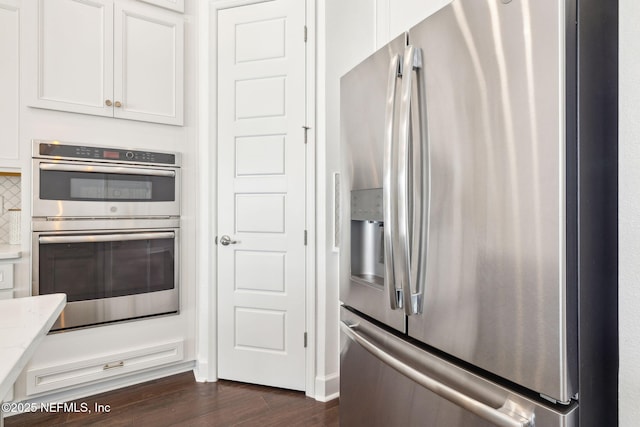 97 Marquesa Cir, Saint Johns, FL 32259 - kitchen with appliances with stainless steel finishes, dark wood-style flooring, light stone countertops, and white cabinets