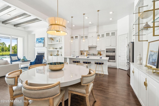 97 Marquesa Cir, Saint Johns, FL 32259 - dining area featuring recessed lighting, dark wood-style floors, a warm lit fireplace, and beamed ceiling