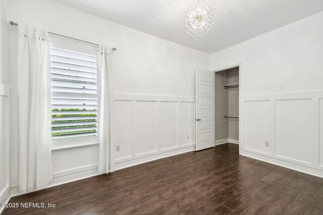 97 Marquesa Cir, Saint Johns, FL 32259 - unfurnished bedroom featuring a decorative wall, a chandelier, dark wood finished floors, and a wainscoted wall