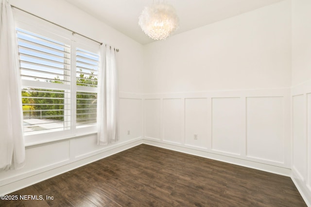 97 Marquesa Cir, Saint Johns, FL 32259 - unfurnished room with a decorative wall, a chandelier, dark wood-style flooring, and wainscoting