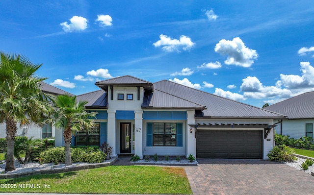 97 Marquesa Cir, Saint Johns, FL 32259 - view of front of house featuring an attached garage, decorative driveway, a metal roof, a front yard, and a standing seam roof