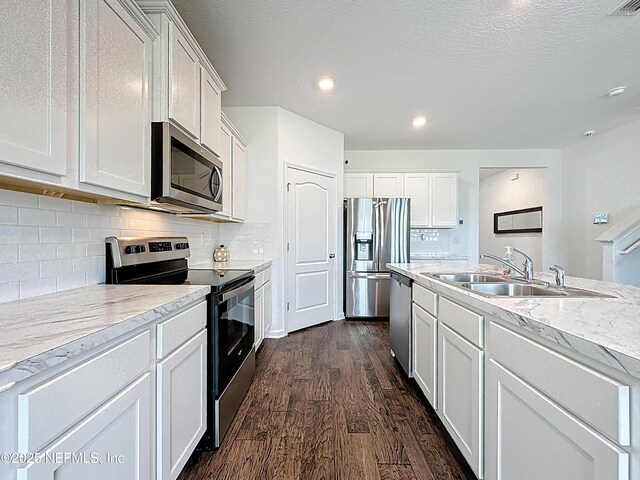 65274 Forest Glen Ln, Yulee, FL 32097 - kitchen with appliances with stainless steel finishes, a sink, dark wood-style floors, white cabinetry, and recessed lighting