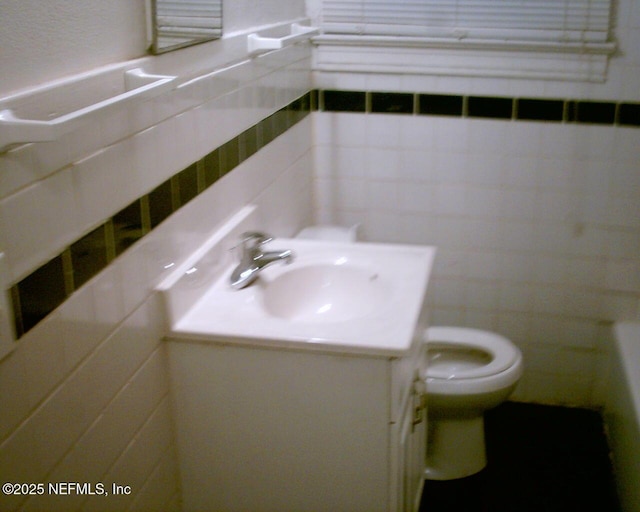 1050 Alderside St, Jacksonville, FL 32208 - bathroom featuring tile walls, toilet, and vanity