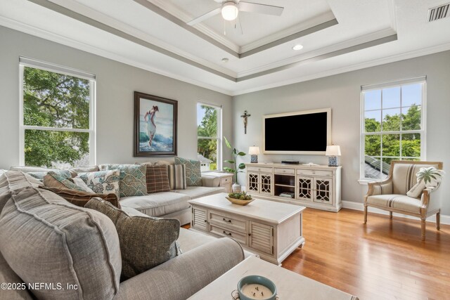 96266 Dowling Dr, Yulee, FL 32097 - living room featuring ceiling fan, light wood-type flooring, ornamental molding, a tray ceiling, and baseboards