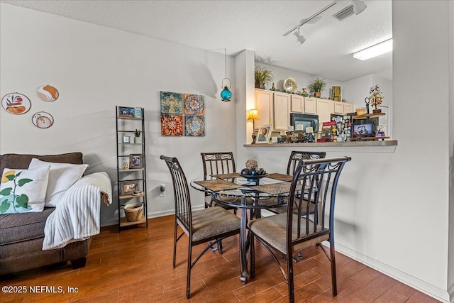 724 Middle Branch Way, Fruit Cove, FL 32259 - dining area with wood finished floors, rail lighting, baseboards, and a textured ceiling
