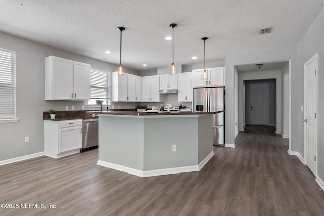 4916 Creek Bluff Ln, Middleburg, FL 32068 - kitchen with stainless steel appliances, dark countertops, white cabinets, dark wood-style floors, and recessed lighting