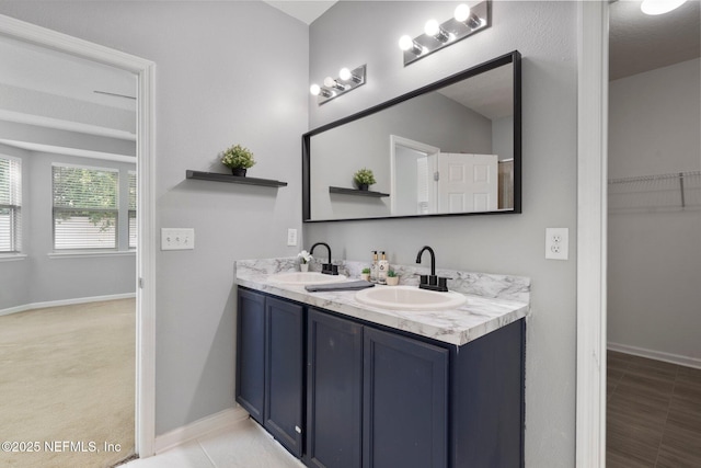 4916 Creek Bluff Ln, Middleburg, FL 32068 - bathroom featuring double vanity, baseboards, and a walk in closet