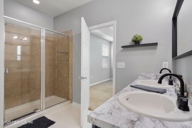 4916 Creek Bluff Ln, Middleburg, FL 32068 - bathroom featuring a stall shower, double vanity, tile patterned flooring, and baseboards