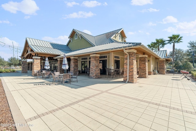 4916 Creek Bluff Ln, Middleburg, FL 32068 - back of house with a standing seam roof, stone siding, metal roof, and a patio area
