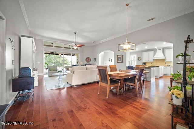 1714 Chatham Village Dr, Fleming Island, FL 32003 - dining room featuring arched walkways, ceiling fan, hardwood / wood-style flooring, crown molding, and a chandelier