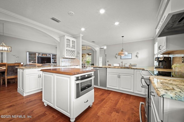 1714 Chatham Village Dr, Fleming Island, FL 32003 - kitchen featuring appliances with stainless steel finishes, arched walkways, a kitchen island, a peninsula, and ornamental molding