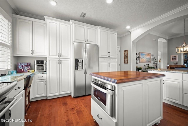 1714 Chatham Village Dr, Fleming Island, FL 32003 - kitchen featuring stainless steel appliances, butcher block counters, arched walkways, white cabinetry, and dark wood finished floors