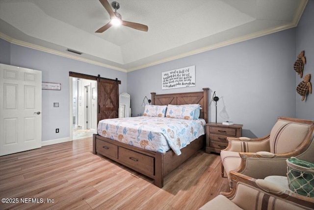 1714 Chatham Village Dr, Fleming Island, FL 32003 - bedroom featuring a raised ceiling, a barn door, light wood-style flooring, a ceiling fan, and ornamental molding