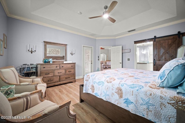 1714 Chatham Village Dr, Fleming Island, FL 32003 - bedroom featuring a raised ceiling, light wood finished floors, a barn door, ornamental molding, and ceiling fan