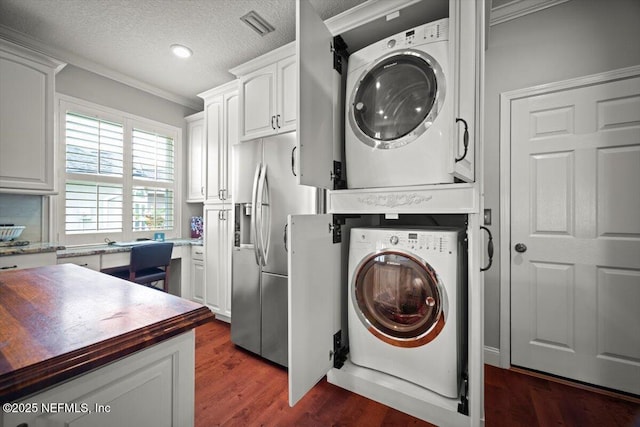 1714 Chatham Village Dr, Fleming Island, FL 32003 - washroom with stacked washer and clothes dryer, crown molding, dark wood-type flooring, and a textured ceiling