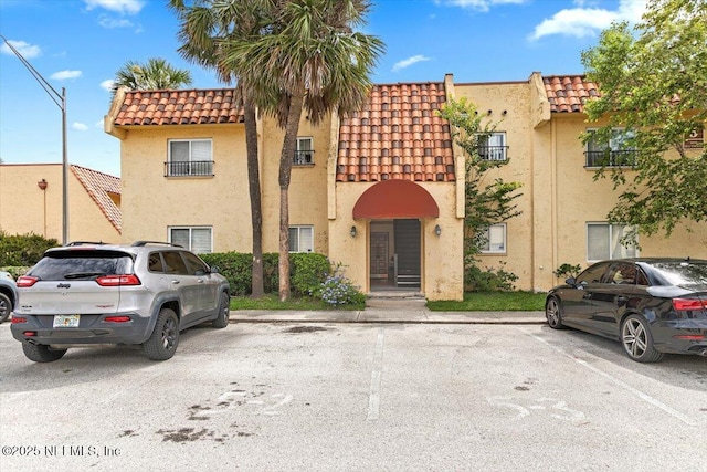 6655 Bell Tower Ct Unit 1, Jacksonville, FL 32217 - townhome / multi-family property with a tiled roof, stucco siding, and uncovered parking
