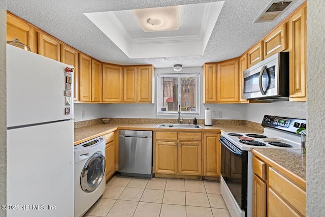 6655 Bell Tower Ct Unit 1, Jacksonville, FL 32217 - kitchen featuring appliances with stainless steel finishes, washer / dryer, a tray ceiling, crown molding, and light tile patterned flooring
