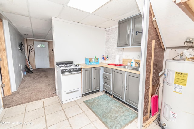 1165 5th St, Macclenny, FL 32063 - kitchen with gray cabinetry, electric water heater, white gas stove, a sink, and a paneled ceiling