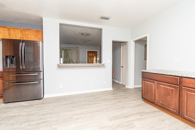 1165 5th St, Macclenny, FL 32063 - kitchen featuring stainless steel refrigerator with ice dispenser, light wood-style flooring, and brown cabinetry