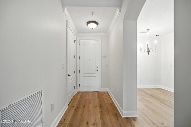 4300 S Beach Pkwy Unit 3214, Jacksonville Beach, FL 32250 - corridor with ornamental molding, light wood-style floors, a chandelier, baseboards, and arched walkways