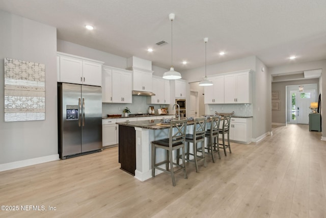 101 Bucktail Ave, Ponte Vedra, FL 32081 - kitchen with appliances with stainless steel finishes, a breakfast bar area, decorative backsplash, white cabinetry, and recessed lighting