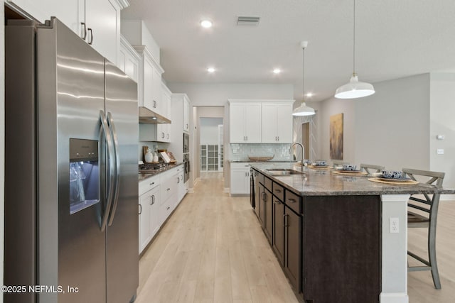 101 Bucktail Ave, Ponte Vedra, FL 32081 - kitchen featuring appliances with stainless steel finishes, a breakfast bar, white cabinetry, dark stone counters, and backsplash