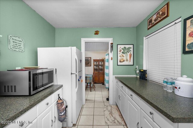 2205 Diana Dr, Palatka, FL 32177 - kitchen with stainless steel microwave, dark countertops, and white cabinets