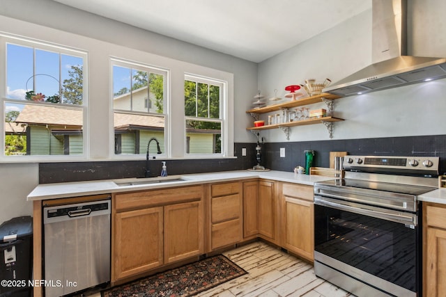 501 Beech St, Fernandina Beach, FL 32034 - kitchen featuring appliances with stainless steel finishes, wall chimney exhaust hood, a sink, light countertops, and light wood finished floors