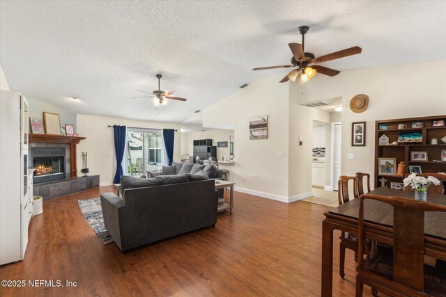2910 Yule Tree Dr, Edgewater, FL 32141 - living room with a ceiling fan, a textured ceiling, lofted ceiling, wood finished floors, and a fireplace
