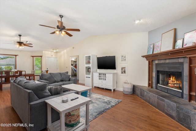 2910 Yule Tree Dr, Edgewater, FL 32141 - living area featuring vaulted ceiling, a tiled fireplace, wood finished floors, ceiling fan, and baseboards