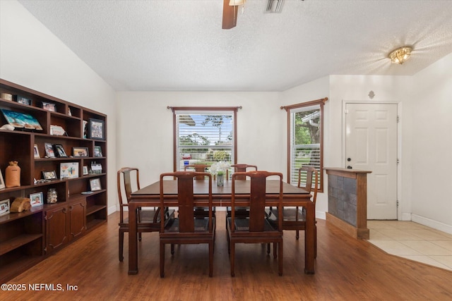 2910 Yule Tree Dr, Edgewater, FL 32141 - dining space featuring a textured ceiling, wood finished floors, a ceiling fan, and baseboards