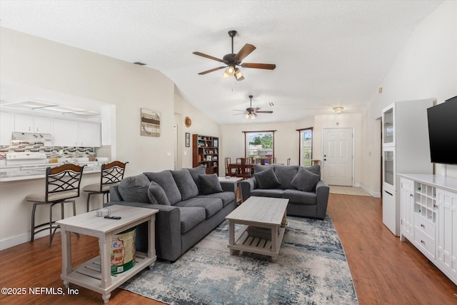 2910 Yule Tree Dr, Edgewater, FL 32141 - living room featuring lofted ceiling, a ceiling fan, wood finished floors, and baseboards