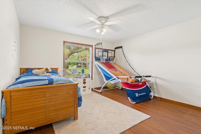 2910 Yule Tree Dr, Edgewater, FL 32141 - bedroom featuring wood finished floors, a textured ceiling, ceiling fan, and baseboards