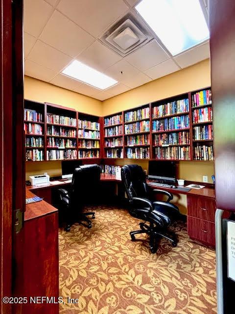 8561 Little Swift Cir Unit 32D, Jacksonville, FL 32256 - carpeted office space with wall of books and a paneled ceiling